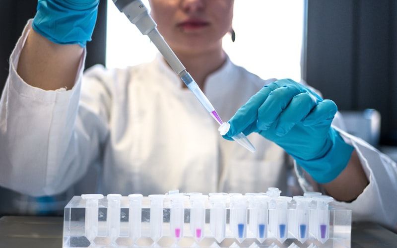 Scientist using pipette in pharmaceutical research laboratory